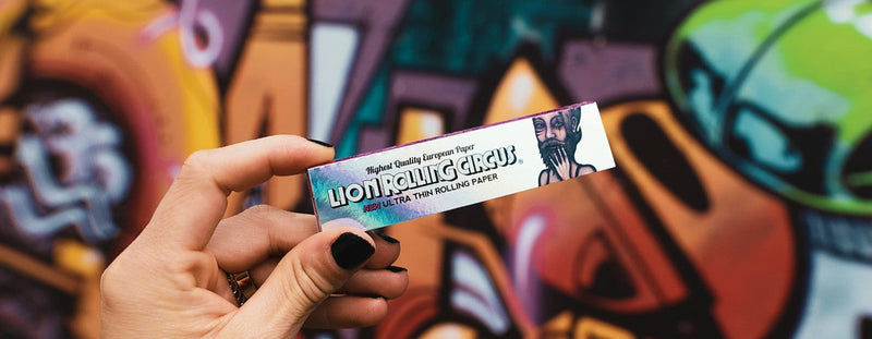 Lion Rolling Circus: papeles Ultra Thin frente a mural artístico de colores